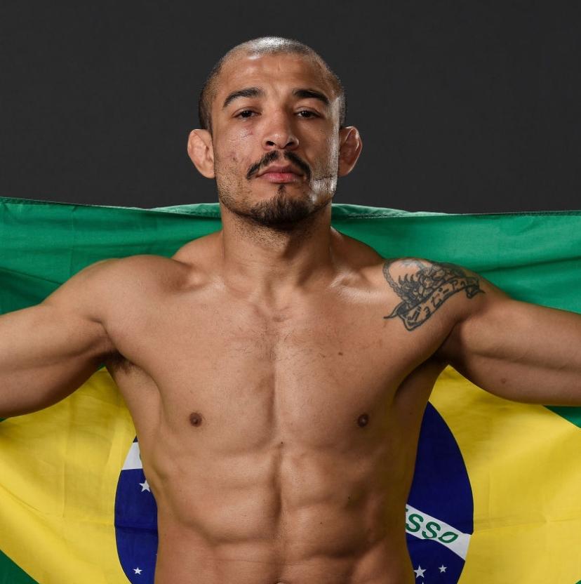 Jose Aldo proudly holding his flag of Brazil behind his back .
